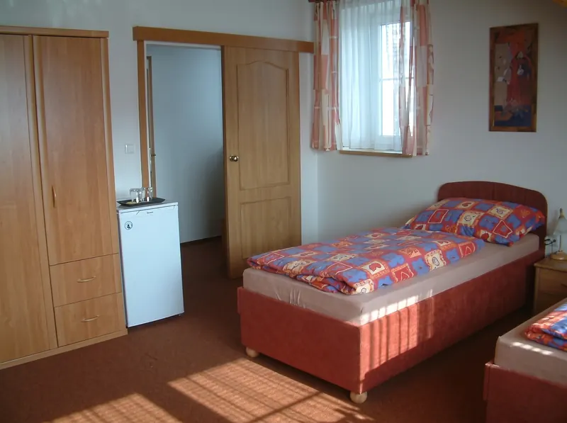 Pokoj s postelí, šatní skříní a oknem