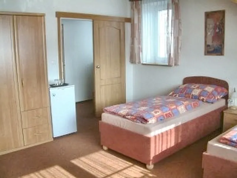 Pokoj s postelí, šatní skříní a oknem