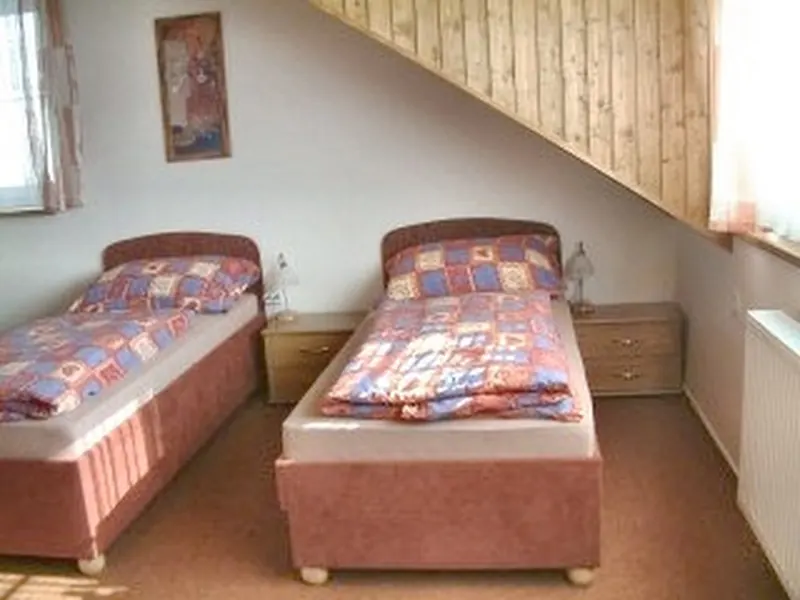 Pokoj se dvěma postelemi pod šikmým stropem
