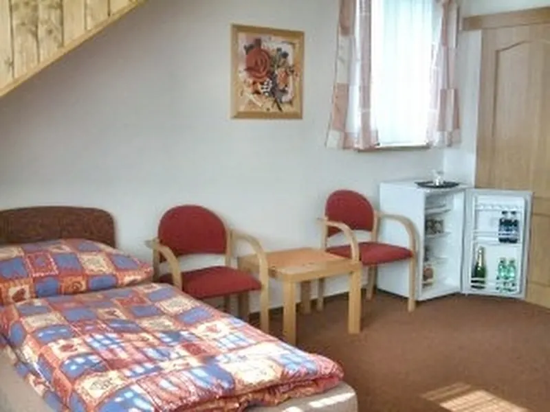 Pokoj s postelí, křesly a lednicí